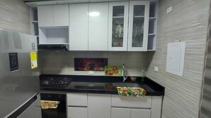 A compact kitchen with stainless steel appliances, white cabinets, and a black countertop. - 5 minutos de Girardot,  casa nuenva amoblada con aire acondicionado (Ricaurte)