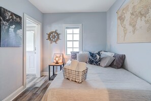 Relax in a spacious bedroom with a large bed, world map, and nautical-themed decor.