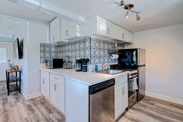 Enjoy cooking and dining in this well-equipped kitchen with a sleek island, dishwasher, refrigerator, and oven.