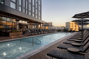 Una piscina al aire libre, sillones reclinables de piscina