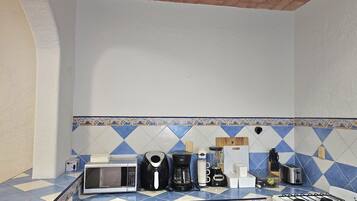 A kitchen with a microwave, coffee maker, toaster, and gas stove.