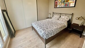 A bedroom with a bed, two bedside tables, a wall-mounted lamp, and a framed artwork above the bed. - Apartment 2 people Toison d'Or district (Dijon)