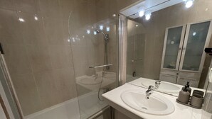 A modern bathroom with a glass-enclosed shower, a white sink, and a mirror with a cabinet above it. - Apartment 2 people Toison d'Or district (Dijon)