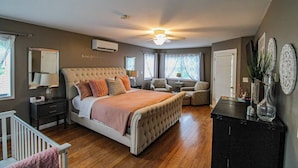 A bedroom with a large bed, a ceiling fan, a dresser, and a desk. - 200' of private waterfront, hot tub & kayaks (Cayuga)