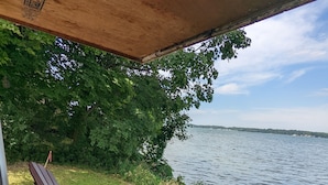 A wooden deck with two chairs and a table, overlooking a lake. - 200' of private waterfront, hot tub & kayaks (Cayuga)