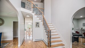 A spacious interior with a wooden staircase, white walls, and a ping pong table. - Beautiful modern villa with pool suana hot tub... (Clintondale)