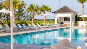 A pool area with lounge chairs and umbrellas, surrounded by palm trees and a gazebo. - “The Ibis” (3025 Southerly Way) 2 person creekside bungalow at Kiawah River ~ Tesla Charger (Johns Island)