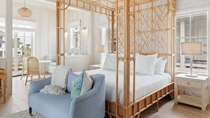 A bedroom with a four-poster bed, a blue sofa, and a large window. - “The Ibis” (3025 Southerly Way) 2 person creekside bungalow at Kiawah River ~ Tesla Charger (Johns Island)