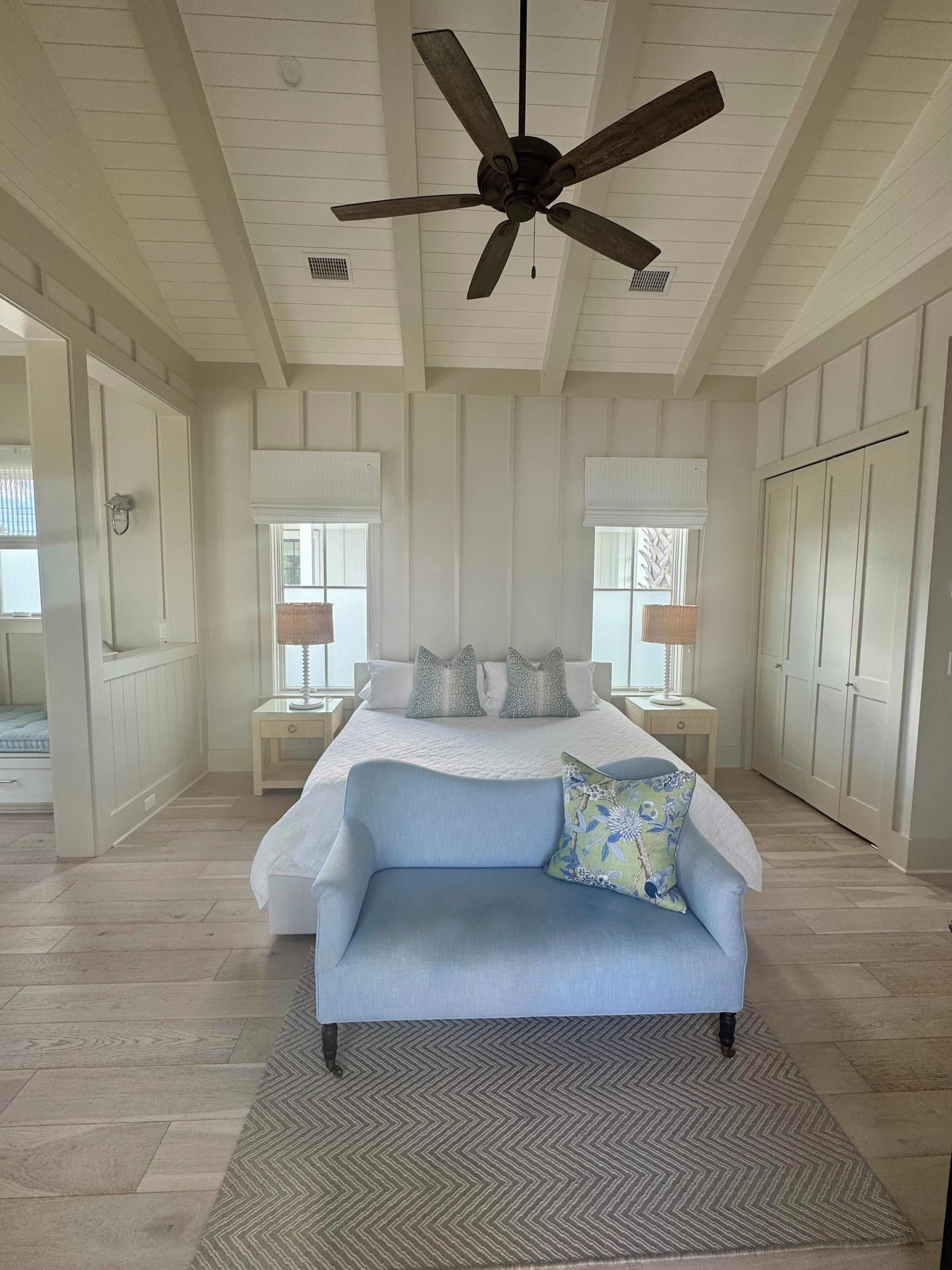 A bedroom with a bed, a ceiling fan, a nightstand, a dresser, and a window with blinds.