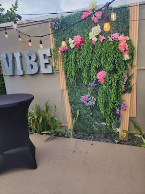 A wall with a vertical garden and a sign that reads "VIBE".