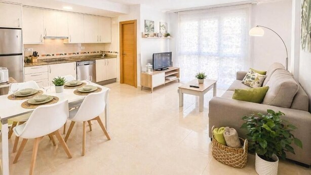 A modern apartment with a dining area, kitchen, living room, and a large window. - Sun apartment (Viveiro)