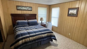 A bedroom with a bed, a nightstand, a lamp, and two windows. - FS Rental #2 Annapolis, MO Black River (Annapolis)