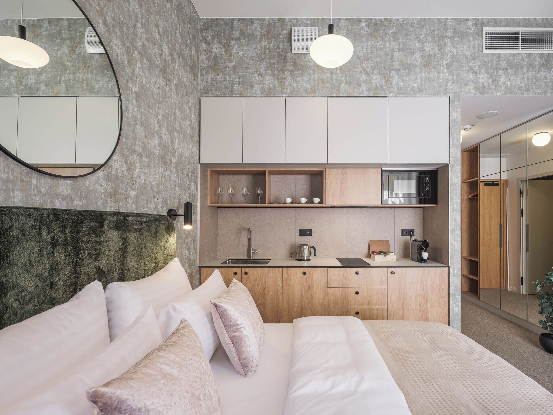 Un dormitorio moderno con una cama grande, cabecera, mesitas de noche y armario empotrado.