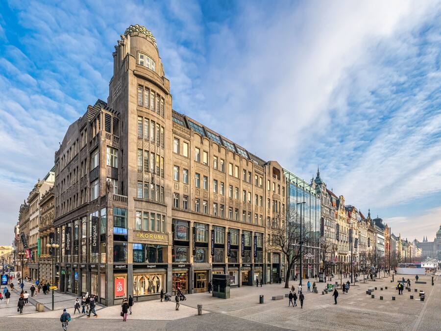 Un edificio histórico de varios pisos, con amplios ventanales y una imponente torre en esquina.