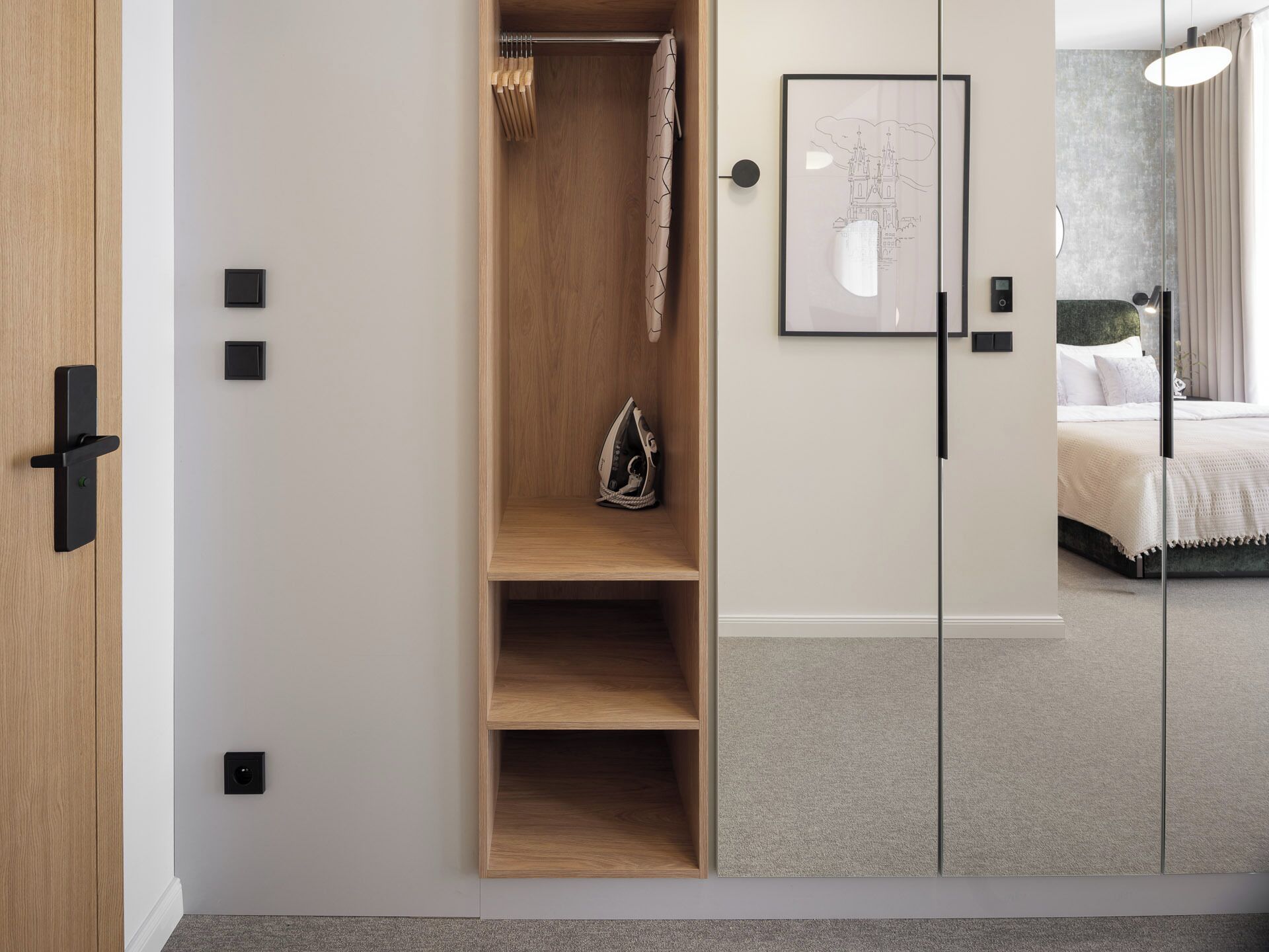 A bedroom with a bed, a bedside table, a nightstand, a wardrobe, and a framed picture on the wall.