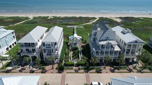 A large, multi-story hotel with a central courtyard, located near a beach.