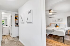 Un dormitorio con cama, mesita de noche y ventilador de techo.