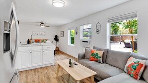 Une cuisine moderne avec des meubles blancs, un réfrigérateur en acier inoxydable et une table à manger en bois.