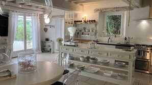 Una cocina moderna con una isla central, electrodomésticos de acero inoxidable y vistas al exterior.