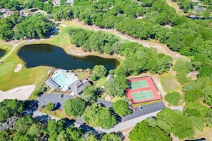 Ein Luftbild eines Anwesens mit Schwimmbad, Tennisplätzen und Teich.