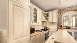 A kitchen with light wood cabinets, a stainless steel sink, and a long countertop. - Sun Spalato Giardino (Split)