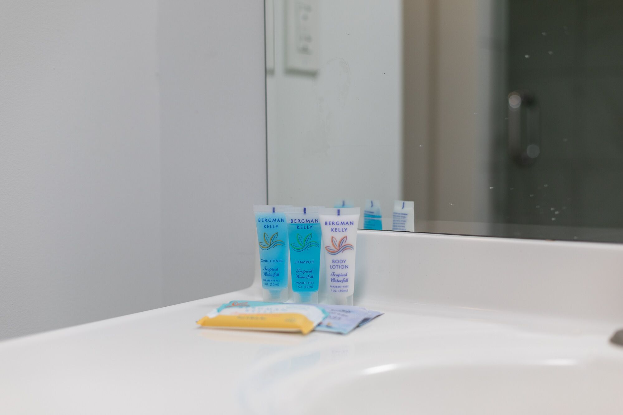 Kylpyhuoneen pesualtaalla on kolme Bergman Kelly -tuotetta: hoitoaine, shampoo ja vartalovoide.