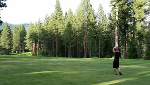 A golf course with a person in a black outfit preparing to swing a golf club. - Short Walk 2Tahoe~Family~Beach~Kings Beach Retreat (Tahoe Vista)