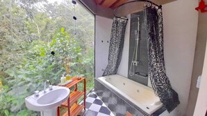 Une salle de bain avec un carrelage à motifs, un lavabo et une douche agrémentée de rideaux à motifs.