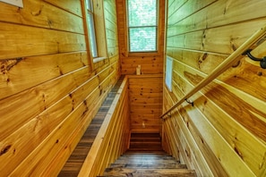 Un intérieur en bois avec un escalier menant à une fenêtre.