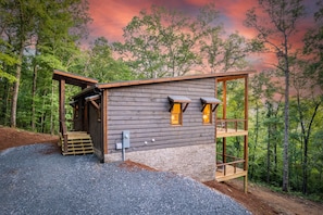 A cabin with a wooden exterior, a porch, and a small deck.