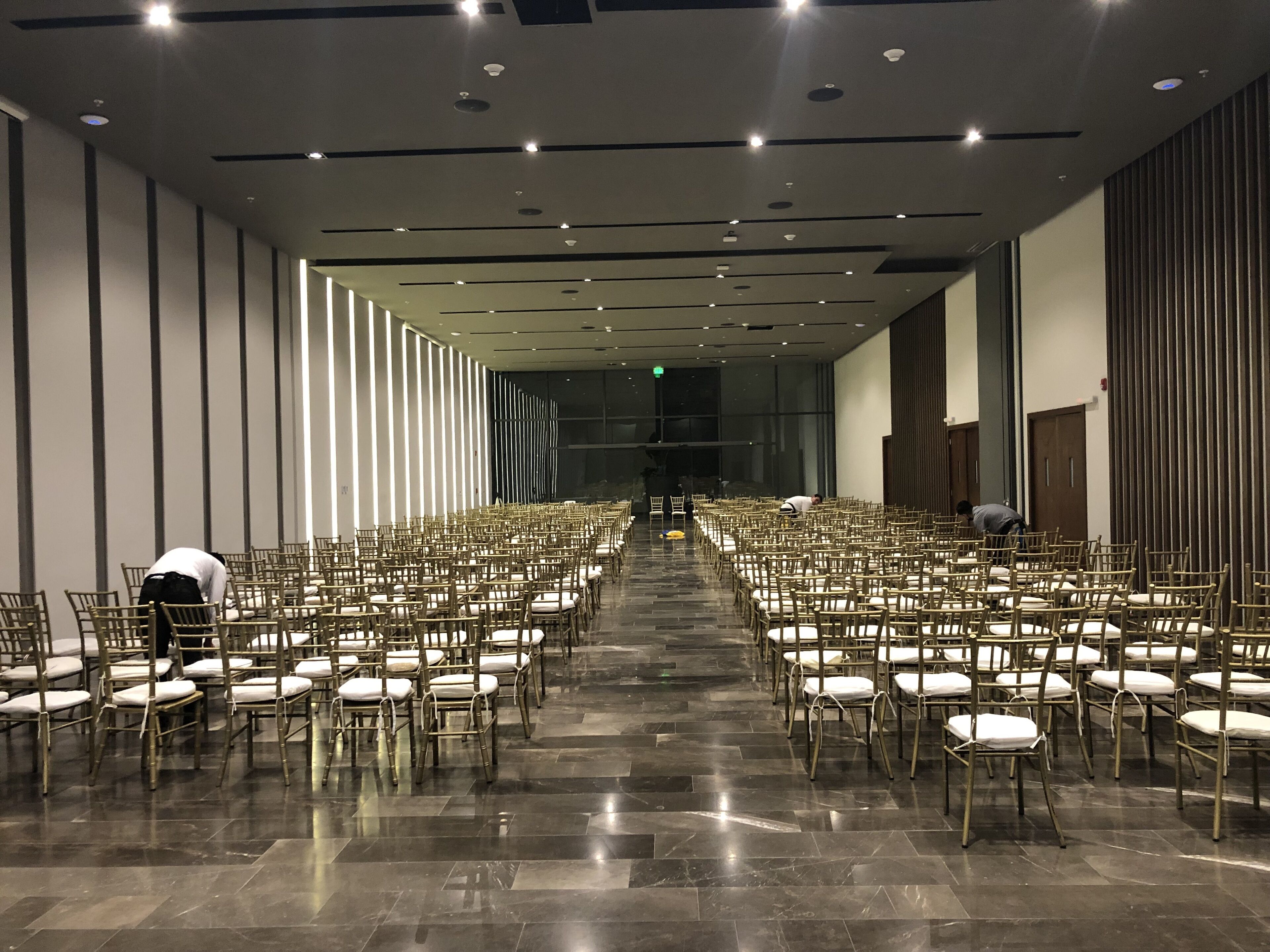 A spacious hall with rows of chairs and a polished floor, likely used for events or conferences.