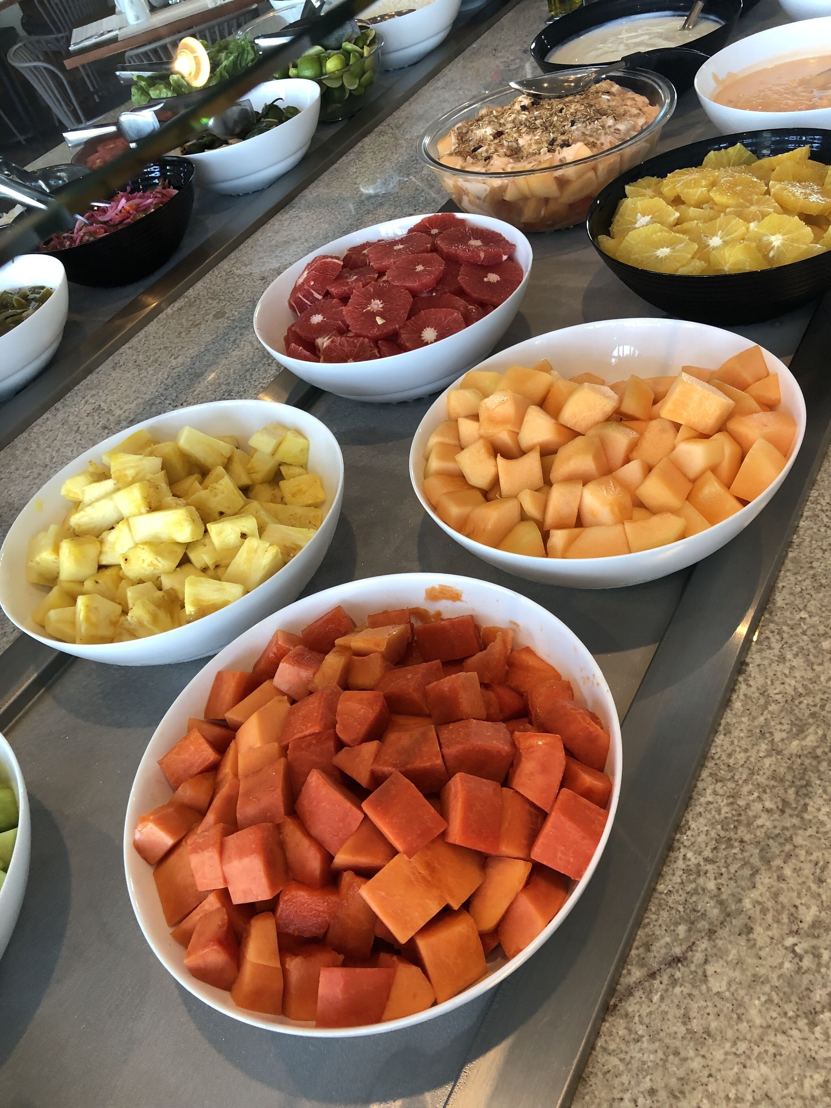 Una mesa de buffet con diferentes fuentes de frutas y verduras.