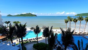 Ein Hotelpool mit Palmen und Meerblick.
