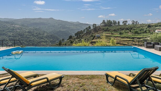 A swimming pool with lounge chairs, surrounded by terraced fields and hills. - Casa Museu da Geada: Room 2 (Cinfães)