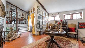 Une pièce au décor traditionnel, avec une table ronde en bois, une chaise rouge et un tapis à motifs.