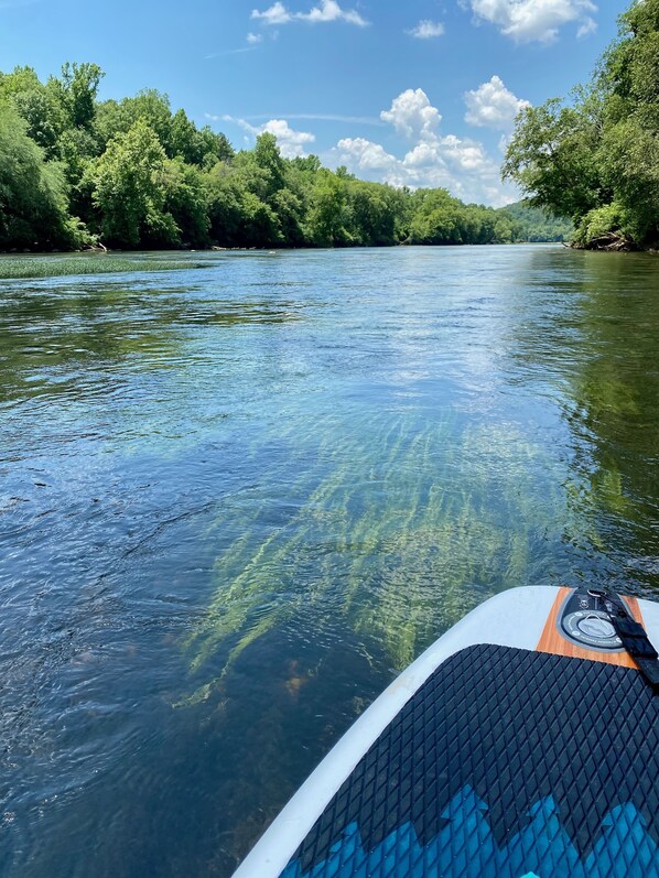 Une rivière aux eaux claires, avec un bateau au premier plan.