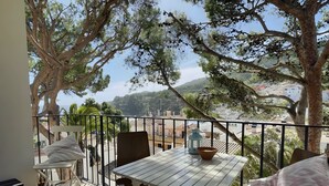 A balcony with a table and chairs, overlooking a cityscape. - Stunning & Intimate views. Terrace + Rooftop. Wifi (Tamariu)