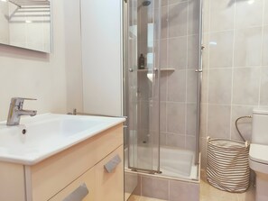 A bathroom with a glass-enclosed shower, a white sink, and a toilet. - Stunning & Intimate views. Terrace + Rooftop. Wifi (Tamariu)