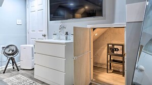 A modern kitchen with white cabinetry, a built-in oven, and a large window above the sink.
