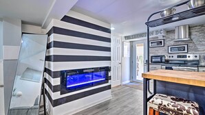 A modern kitchen with a built-in fish tank, stainless steel appliances, and a striped wall design.