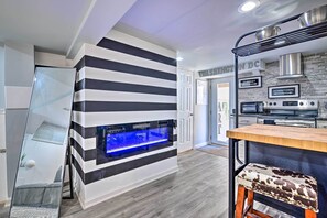 Uma cozinha moderna com aquário integrado, eletrodomésticos de aço inoxidável e design de parede listrada.