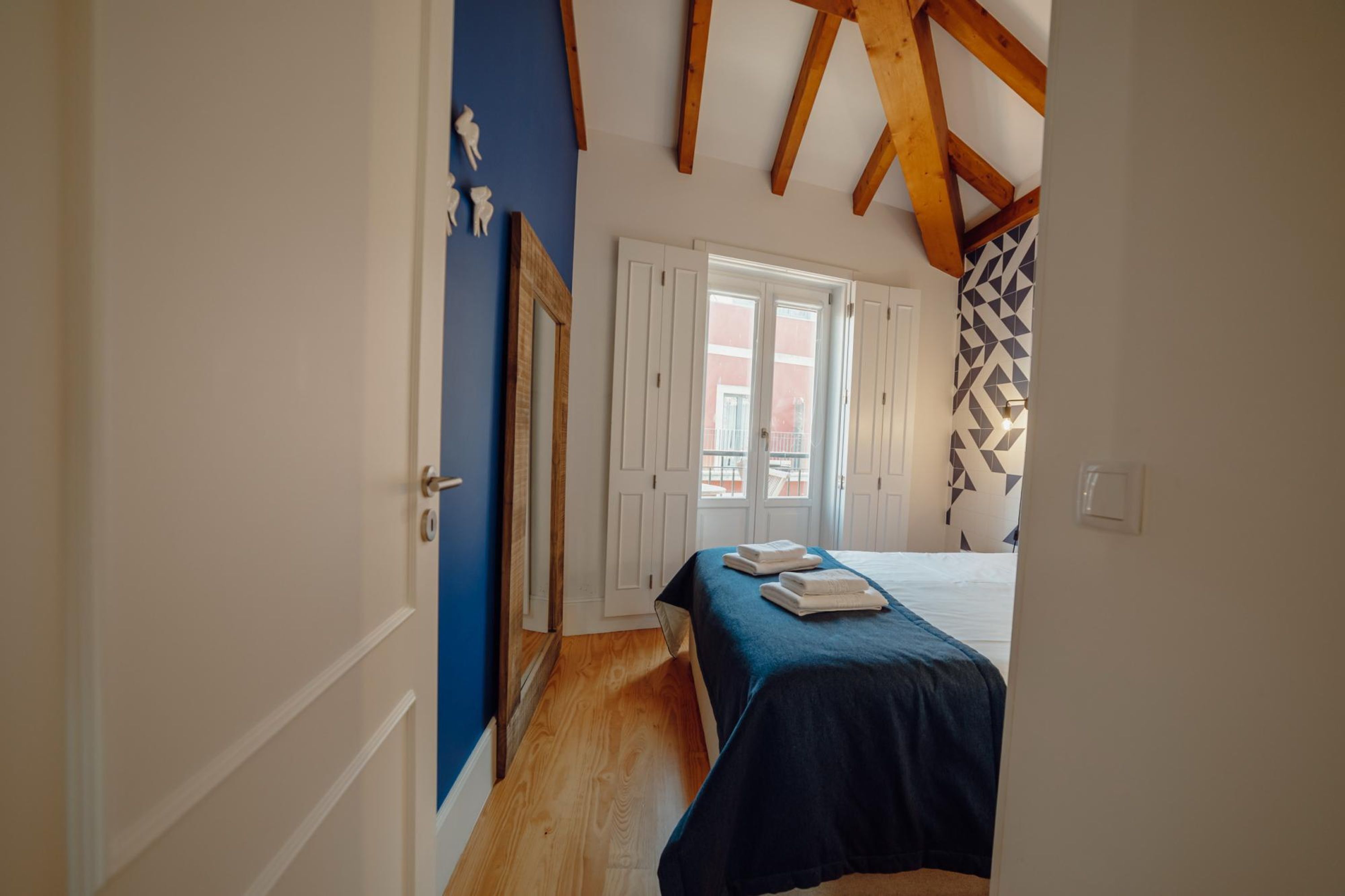 A bedroom with a bed, a window, and a door.