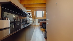 A modern kitchen with a long countertop, stainless steel appliances, and a window above the sink. - Elegant Downtown Apartment by Vacationy (Porto)