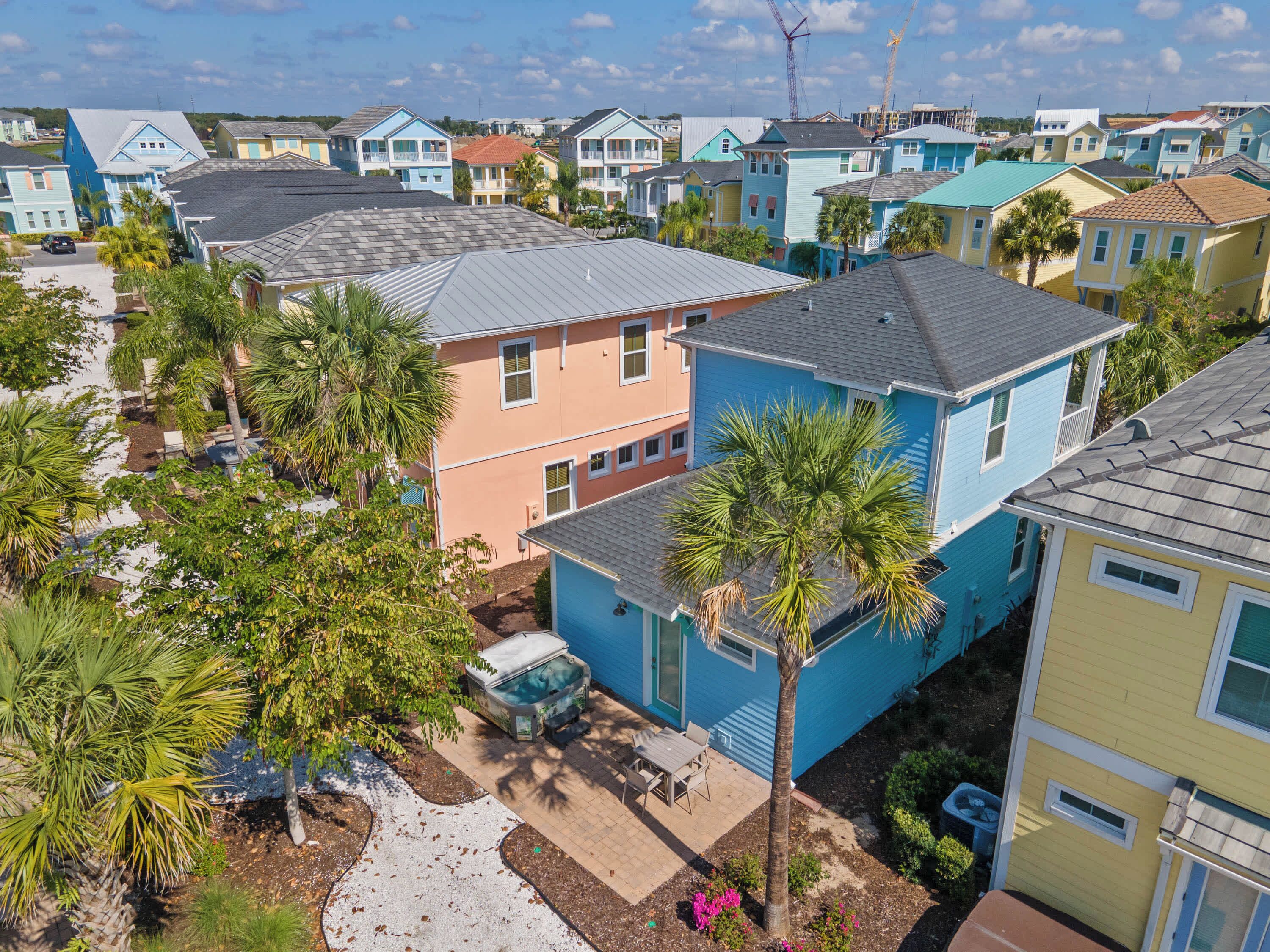A residential area with colorful houses, a swimming pool, and palm trees.