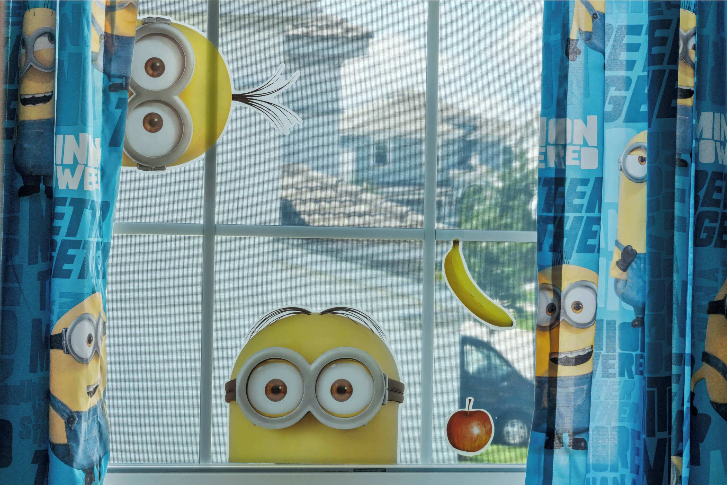 Una ventana con cortinas que presentan personajes de Minions.