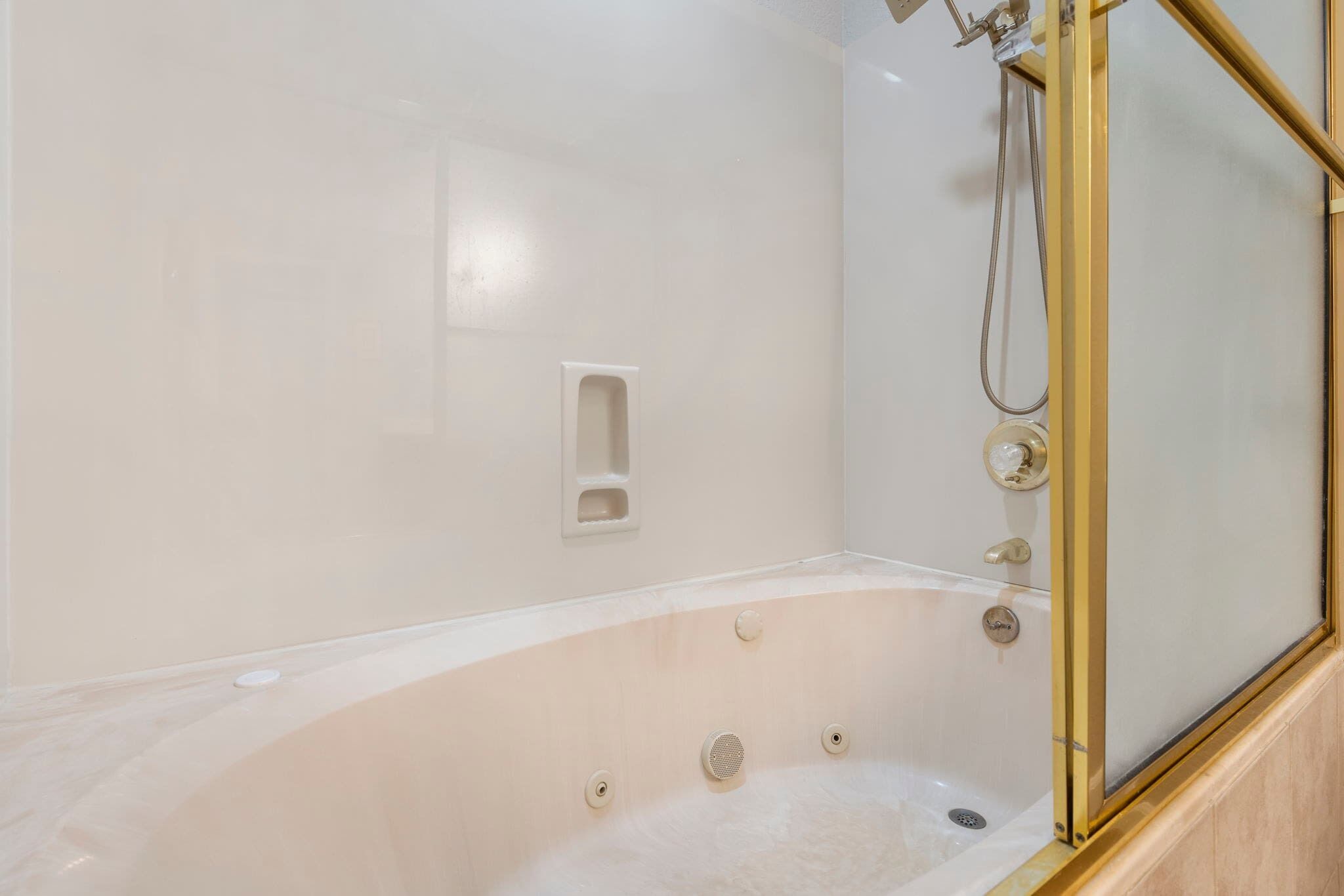 Une salle de bain moderne avec une baignoire sur pieds, une douche à parois de verre et un distributeur de savon fixé au mur.