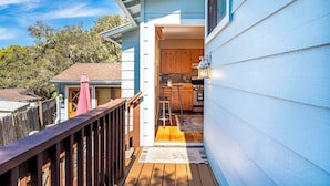 A wooden deck leading to a house with a kitchen area visible through an open door. - Quaint Carmel - Bungalow Close to Beach (Carmel)