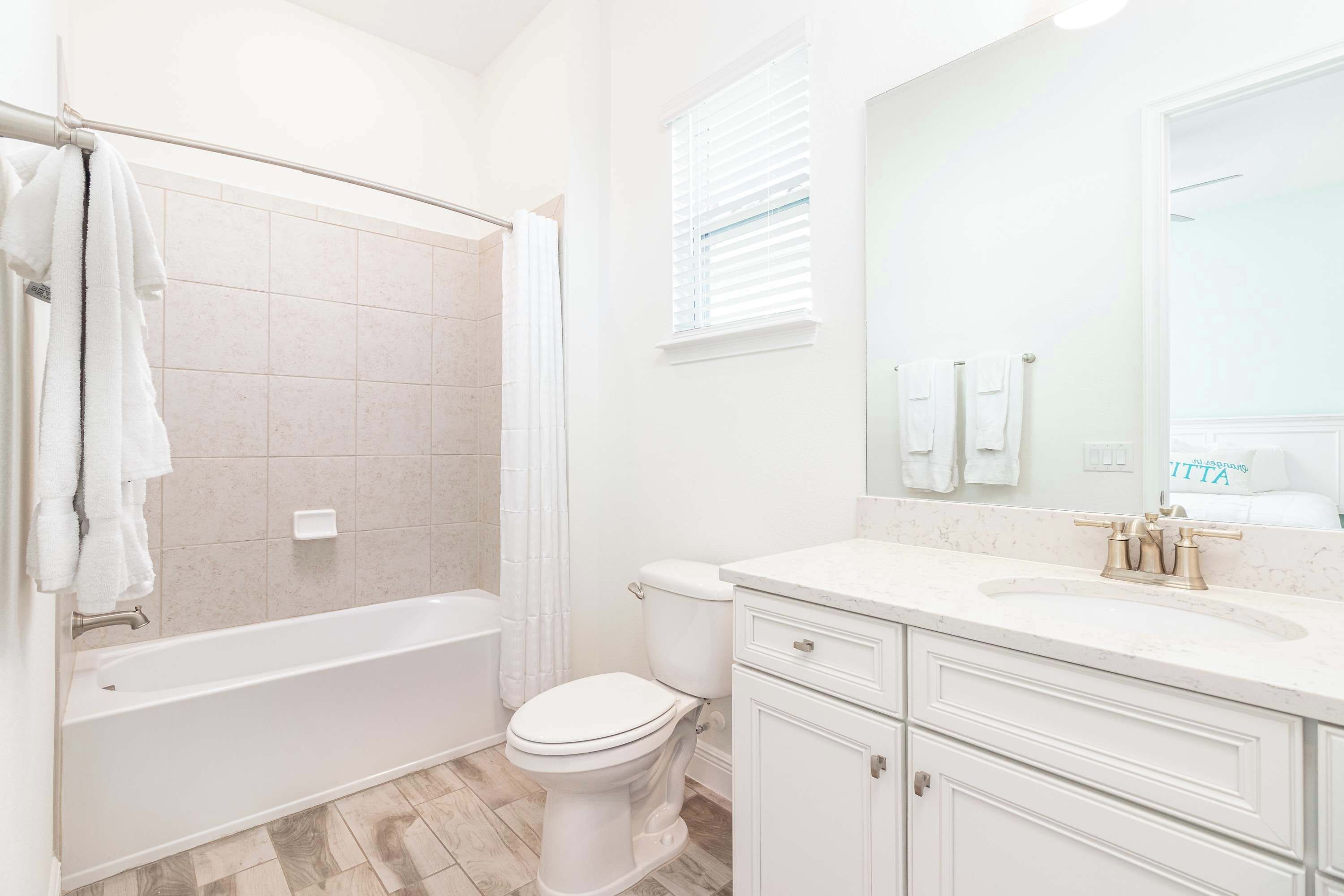 Un bagno con vasca, servizi igienici e lavabo con cassetti.