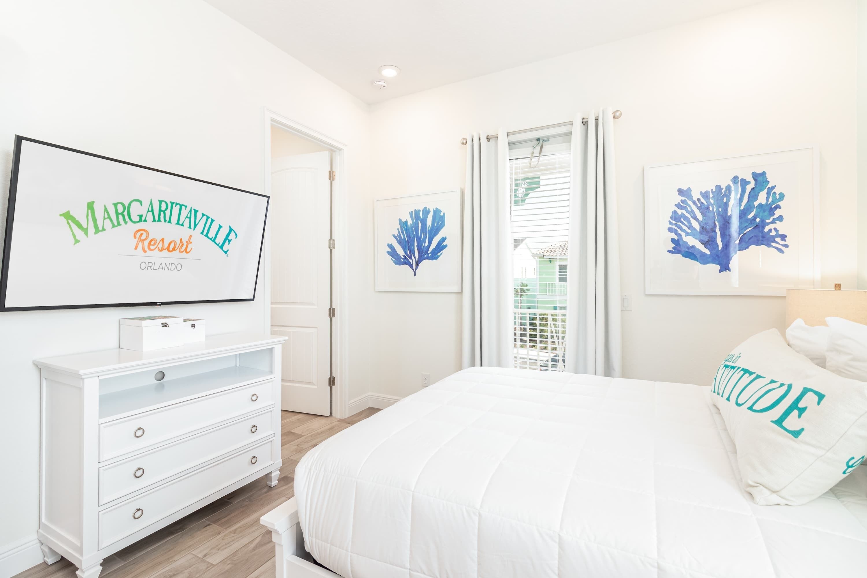 Une chambre à coucher avec un lit, une commode et des œuvres d’art accrochées au mur.