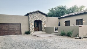 A house with a stone entrance, a garage, and a patio area. - Custom built family home, close to balloon fiesta park  (Albuquerque)
